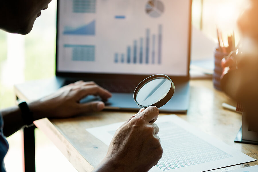 Businessman looking through a magnifying glass